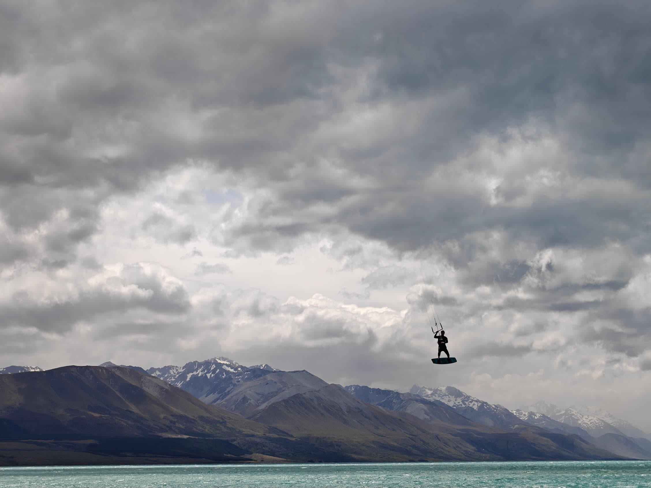 Kitesurfer hoog in de lucht boven het water